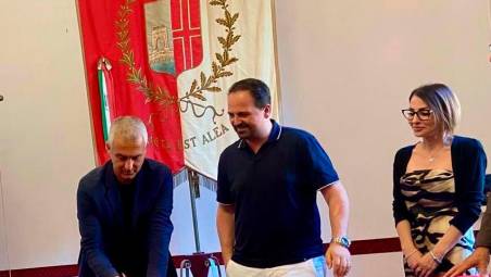 Il sindaco di Rimini, Jamil Sadegholvaad, mentre firma con Stefano Petracca e Stefania Di Salvo