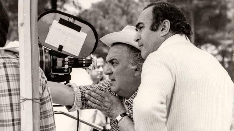 Fellini sul set con l’amico Titta Benzi (Foto Minghini)