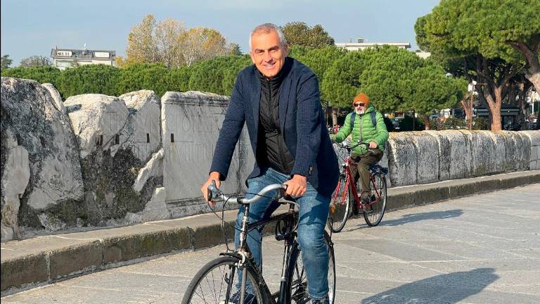 Il sindaco in bici mentre pedala sul Ponte di Tiberio