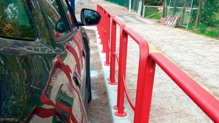 La nuova pista ciclabile, con transenna, di fianco ai parcheggi per le auto