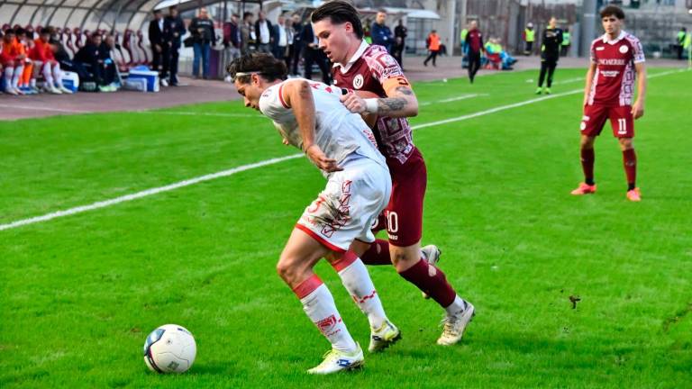 Luca Falbo contrastato dal capitano e attaccante aretino Emiliano Pattarello nel match pareggiato domenica (foto Federico Roggi)