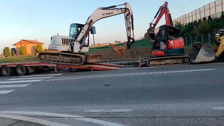 A destra l’escavatore rosso che si era rovesciato dopo l’impatto contro il sottopasso